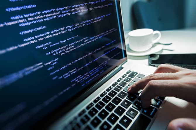 صورة لـ أسباب تجعل أجهزة Mac أقل عرضة للبرامج الضارة مقارنة بـ Windows | Computer-programmer-working-on-a-Mac-min-DzTechs