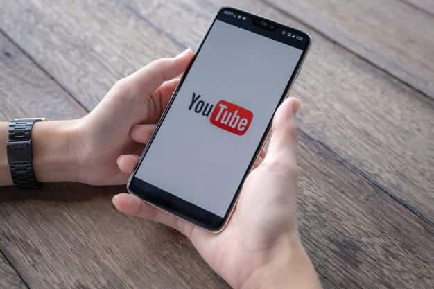 صورة لـ كيفية تنزيل مقاطع فيديو YouTube إلى معرض الكاميرا على iPhone | hombre_mostrando_aplicacion_youtube_smartphone_89286_42-MV6QhLfs-DzTechs