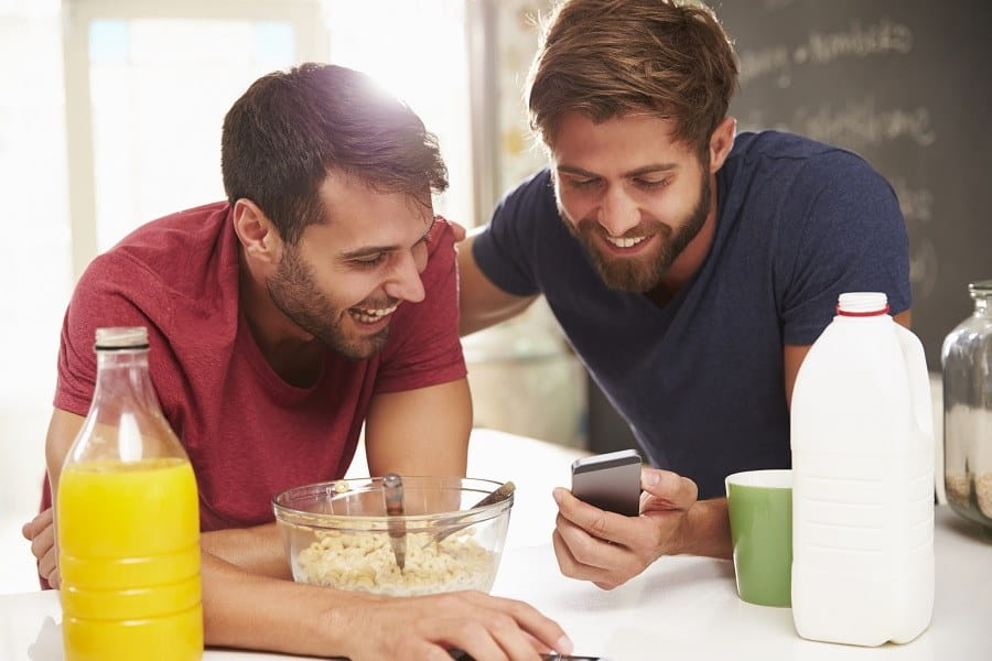 صورة لـ أفضل تطبيقات زملاء السكن لإدارة الحياة معًا على iOS و Android | Two_Male_Friends_Having_Breakfast_And_Reading_Text_Message-9xvq1bgs-DzTechs