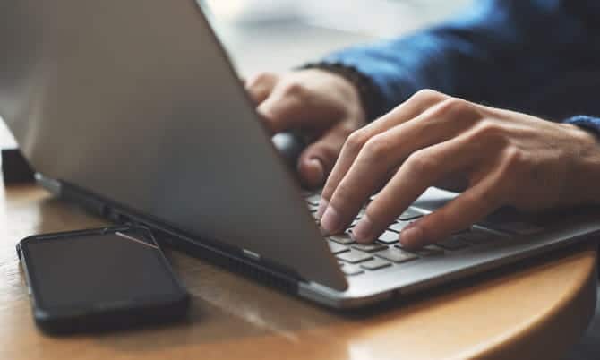 صورة لـ كيفية كتابة مراجعات الأفلام على الانترنت وكسب المال من القيام بذلك | Image_of_person_typing_on_a_laptop-RD4d3Pfs-DzTechs