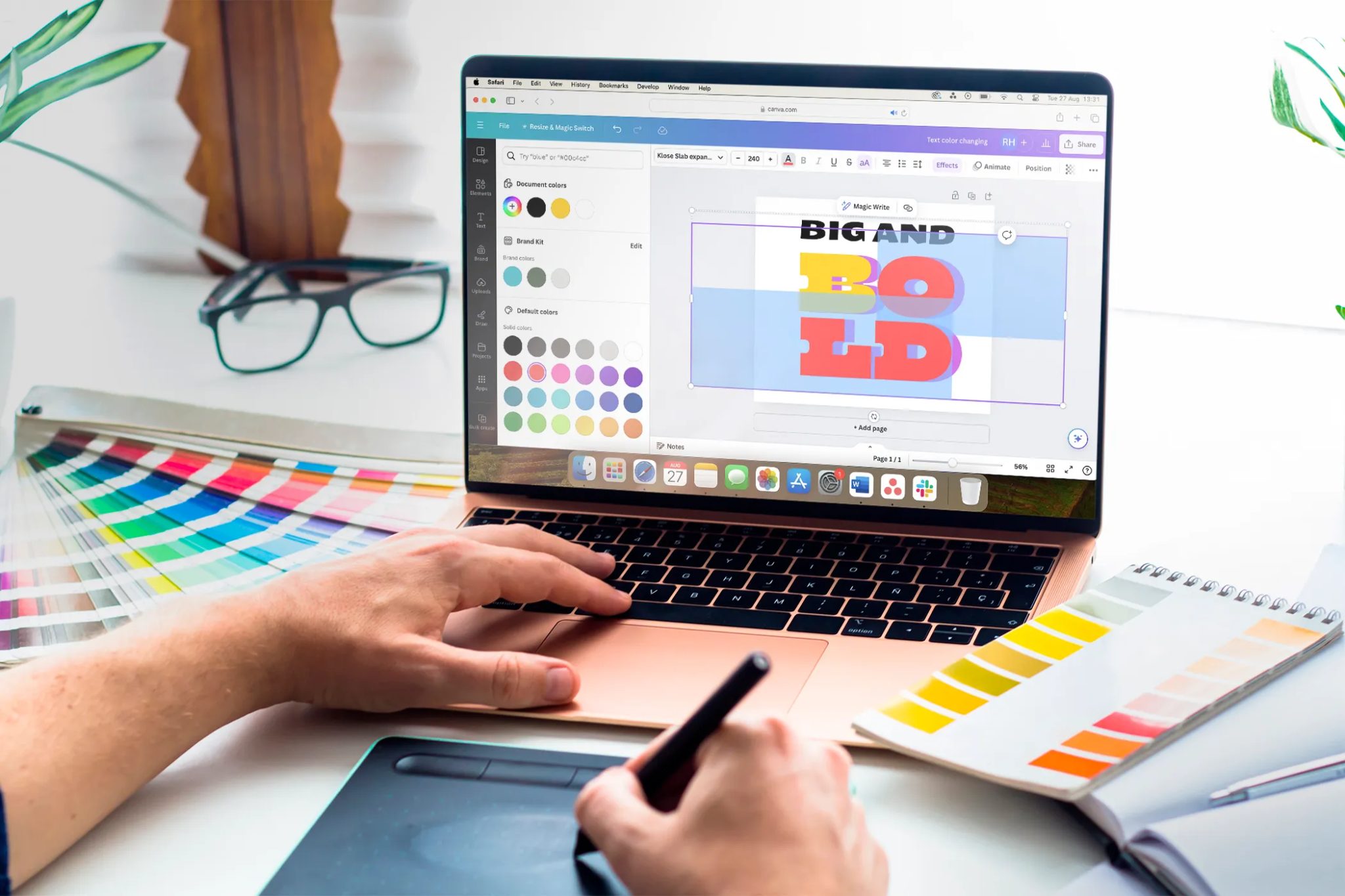A laptop with Canva open on a table with some design tools.