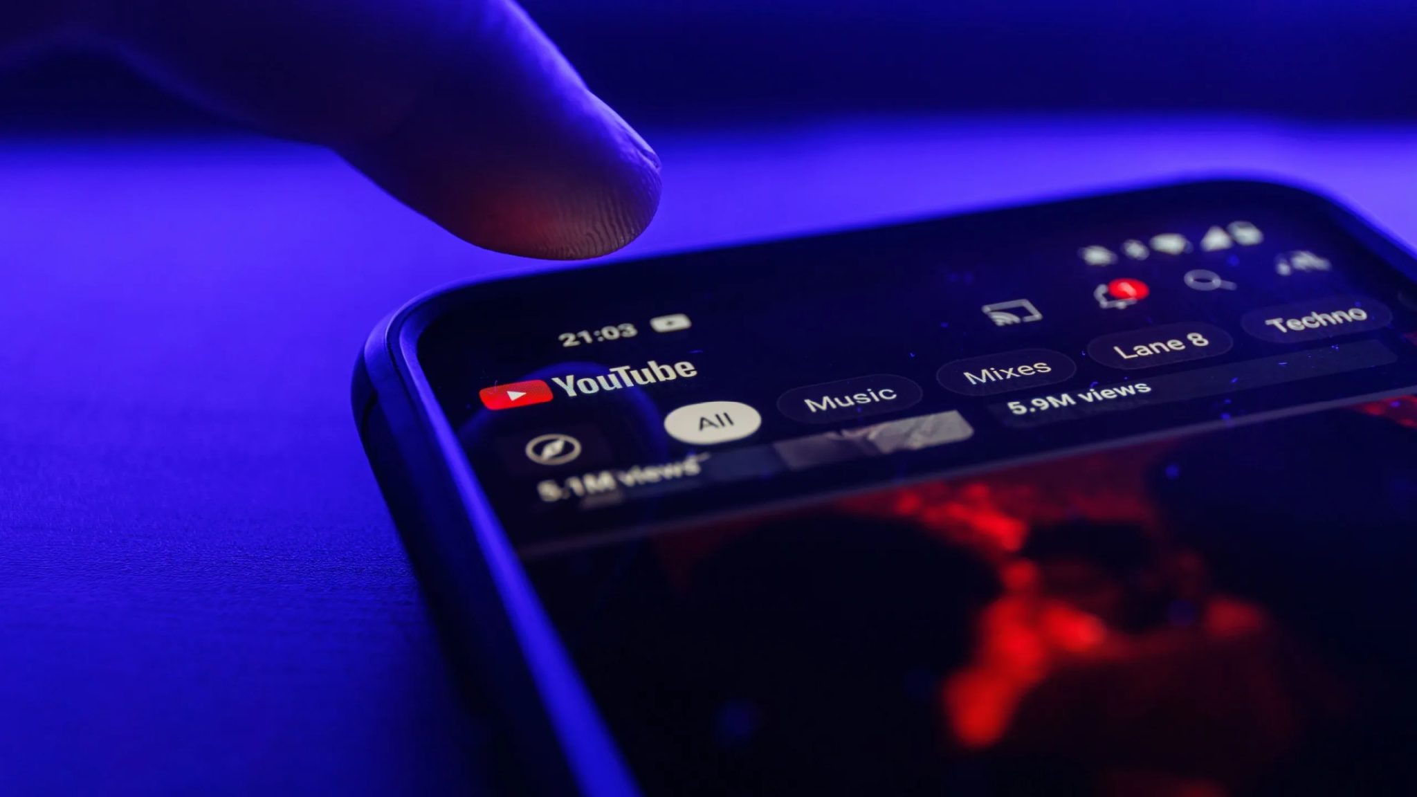 إصبع ينقر على تطبيق YouTube للهاتف المحمول