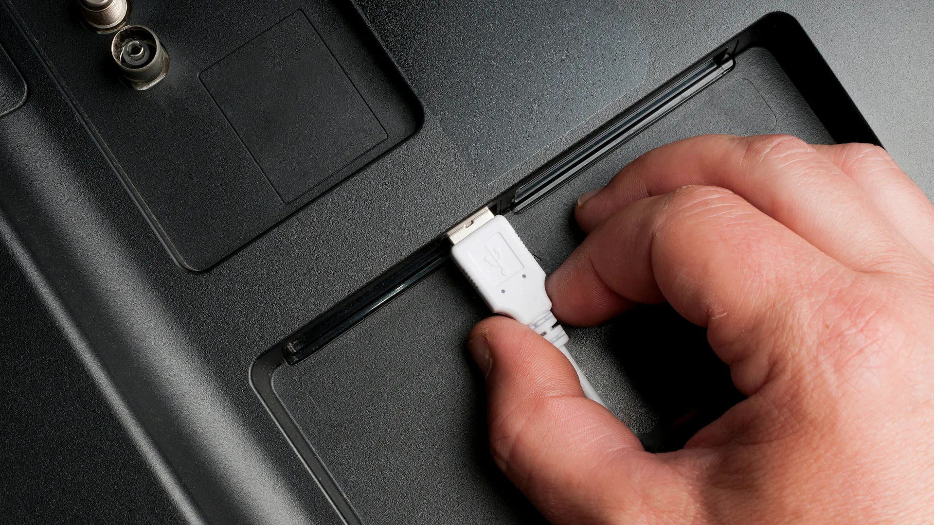 رجل يوصل كابل USB من النوع A بمنافذ خلفية للتلفزيون