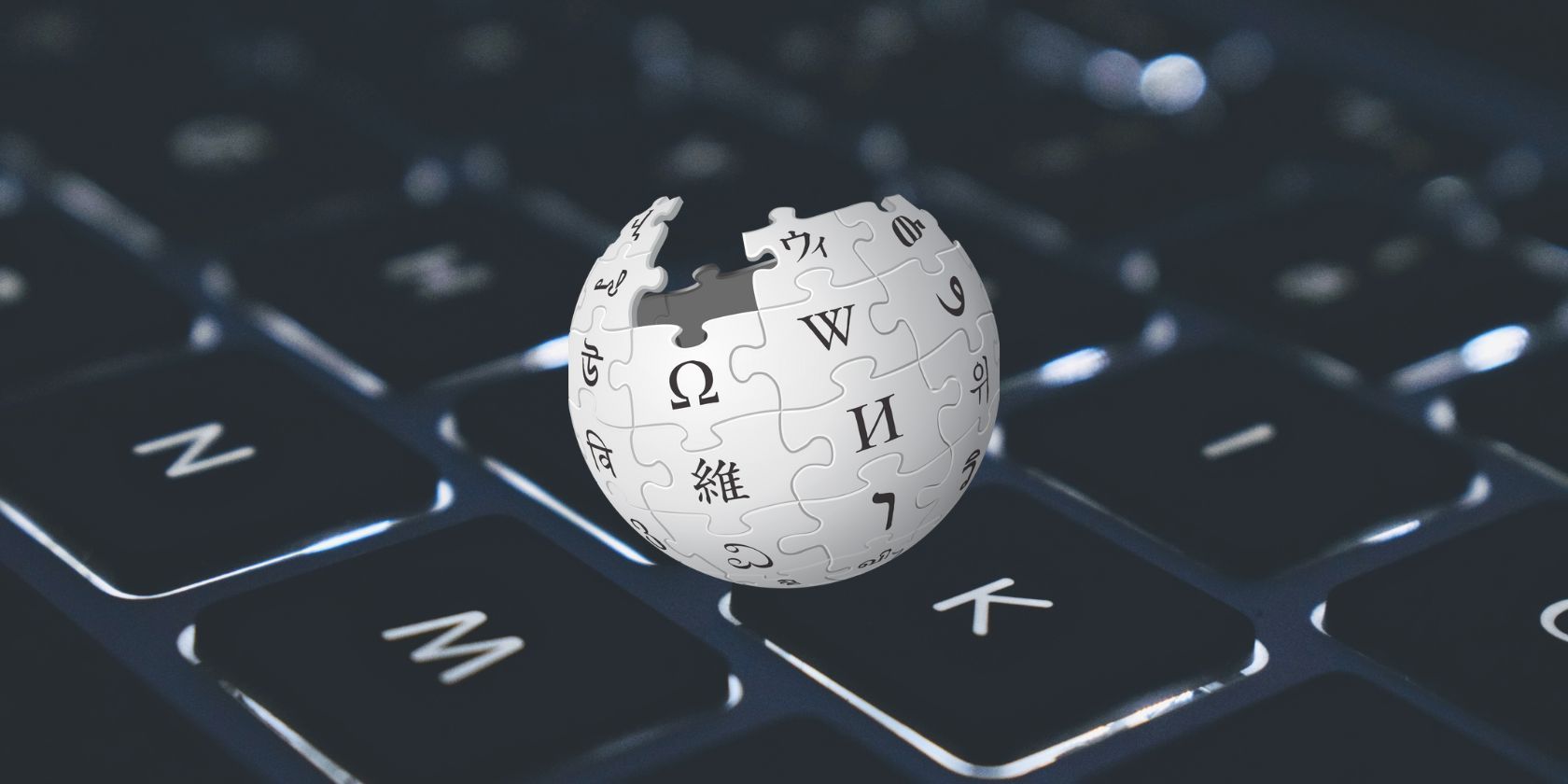 صورة لشعار ويكيبيديا أمام خلفية لوحة مفاتيح