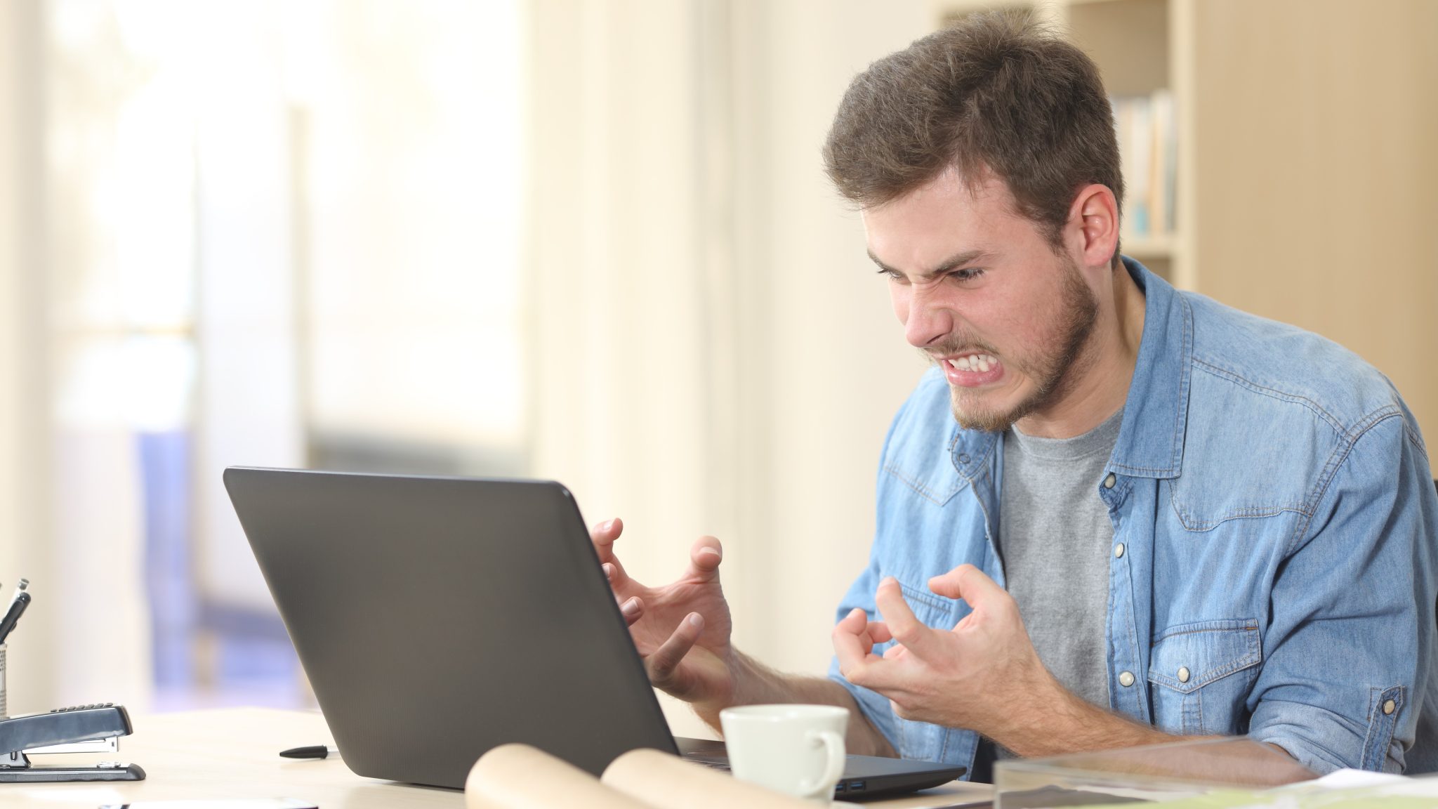 رجل غاضب من جهاز الكمبيوتر المحمول الذي يعمل بنظام Windows 11