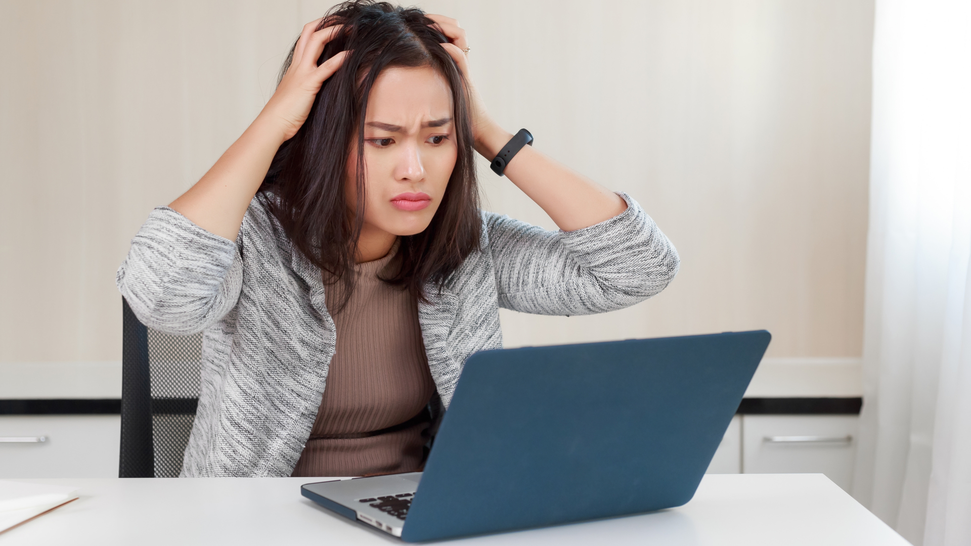 امرأة غاضبة تستخدم جهاز كمبيوتر محمول